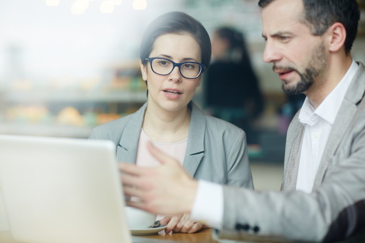 two business people showing the computer and discussing the details about business