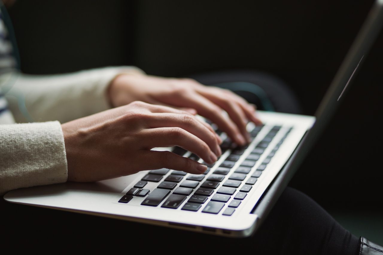 a person writing on a laptop from a view